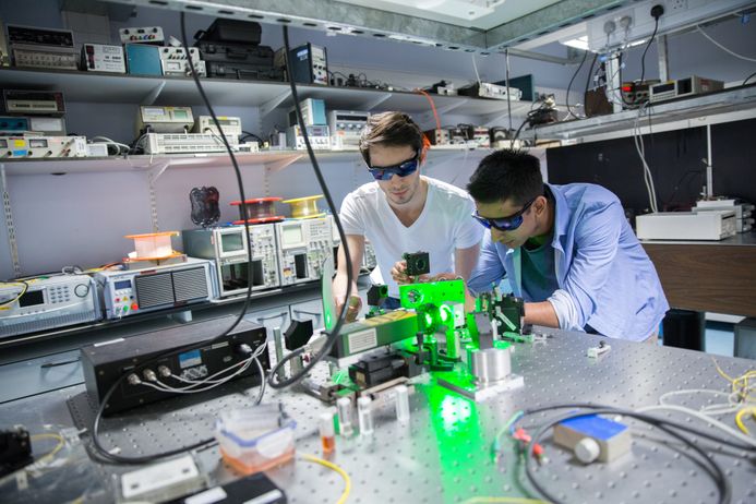 Two students working with lasers in the Department of Physics